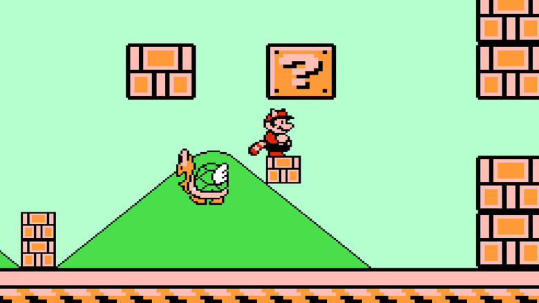 Egy Tanooki-öltönyű Mario áll egy nagy parakoopa által kinagyított kérdőjel alatt. 