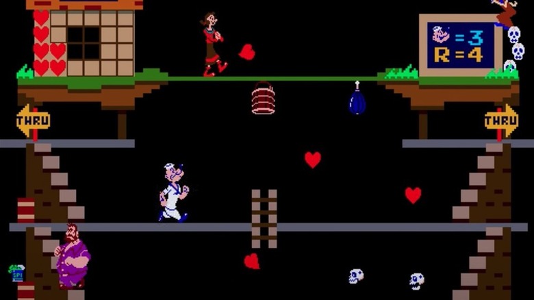 Popeye az Olive Oyl alatt és a Bluto felett lépked a Popeye-ben szívekkel ellátott emelvényen