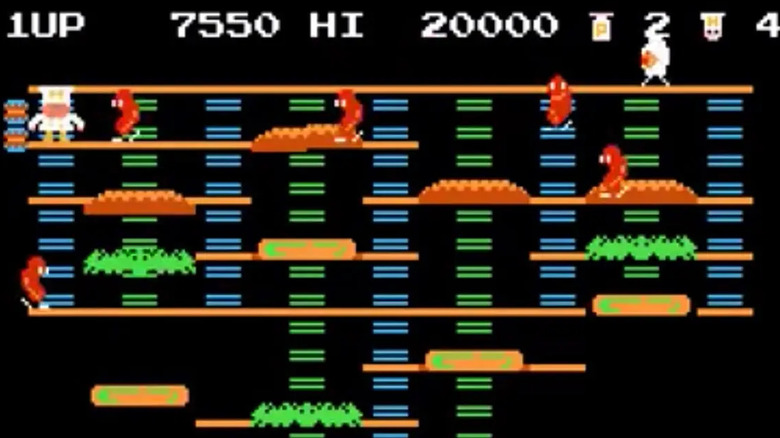 Peter Pepper lemászik a létrán, miközben előretörő kolbászok veszik körül a BurgerTime-ban