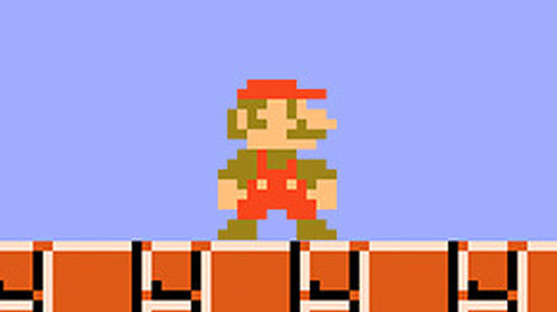 Mario egy barna tégla alapon áll a Super Mario Bros.