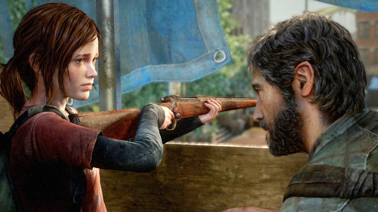 Ellie Joel Millerre néz, miközben puskát tart a The Last of Us-ban