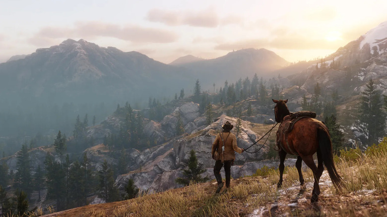 Arthur Morgan a Red Dead Redemption II-ben napkeltekor egy hegyvonulaton sétál a lovával