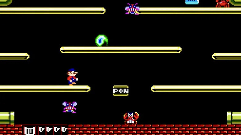 Mario egy emelvényen áll, kilátással egy rákra és egy grimaszolt légyre a Mario Bros.