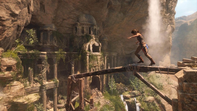 Lara Croft egy gerendán egyensúlyoz egy templom mellett a Rise of the Tomb Raiderben