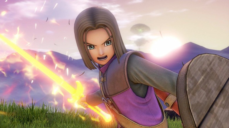 A hős kiált, miközben pajzsot és izzó kardot tart a Dragon Quest XI-ben