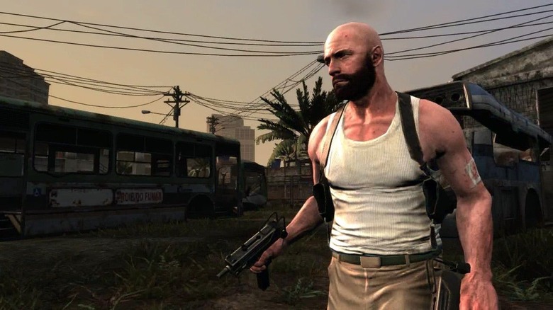 Max Payne géppisztolyt tartva sétál át egy favelán a Max Payne 3-ban