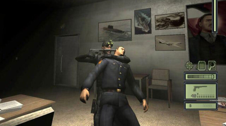 Sam Fisher pisztolyt tart egy férfi fejéhez a Splinter Cellben