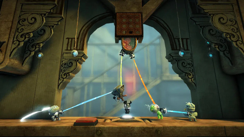 A Sackboys egy csoportja színes szálakat húz a LittleBigPlanet 2-ben