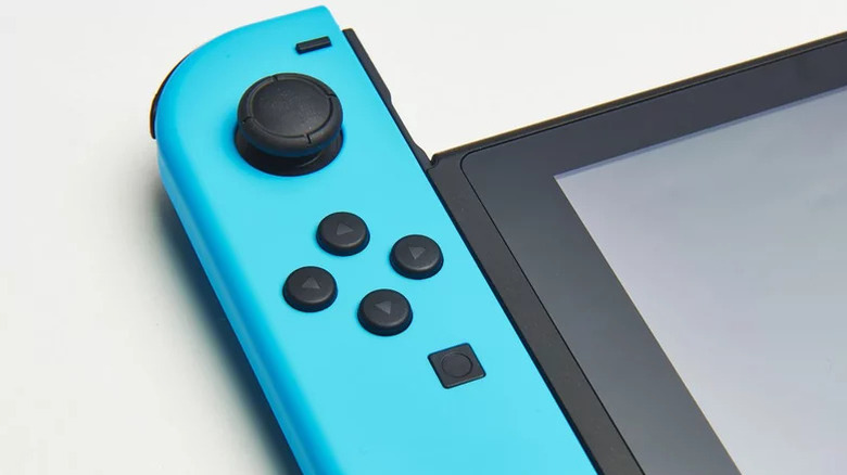 Egy kék Joy-Con csúszik ki egy Nintendo Switch kézi számítógépből