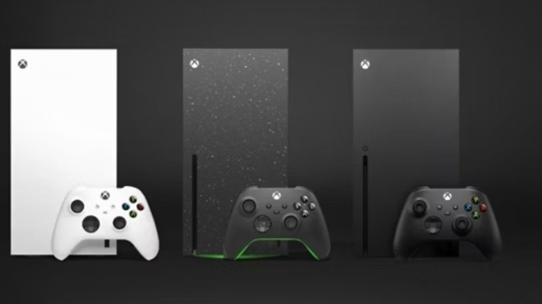 Három Xbox Series X és vezérlőik állnak egymás mellett