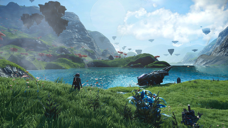 Egy játékos karakter a No Man's Sky egyik füves dombjáról mér fel egy nagy tavat