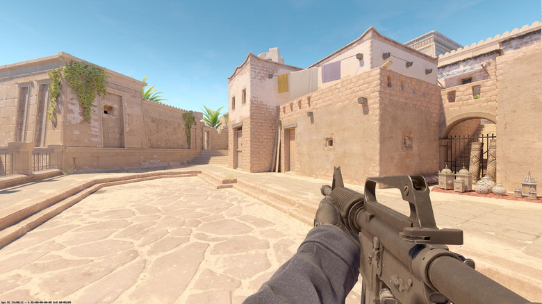 Egy játékos egy géppuskát tart a Counter-Strike 2 udvarán
