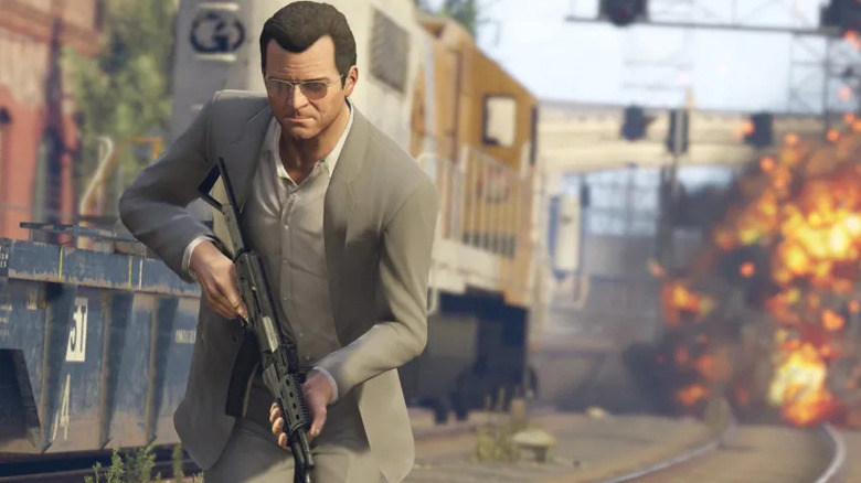 Michael De Santa elsétál egy robbanás elől, miközben egy gépkarabélyt tart a Grand Theft Auto 5-ben
