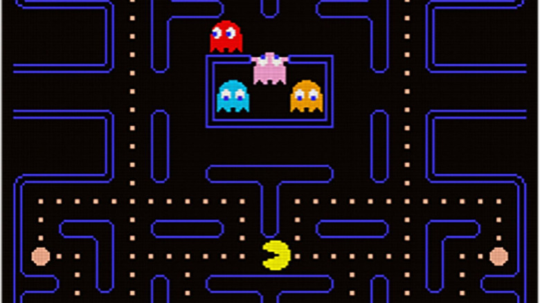 Színes szellemek bújnak elő egy cellából, miközben a Pac-Man pontokat eszik alattuk a Pac-Manben