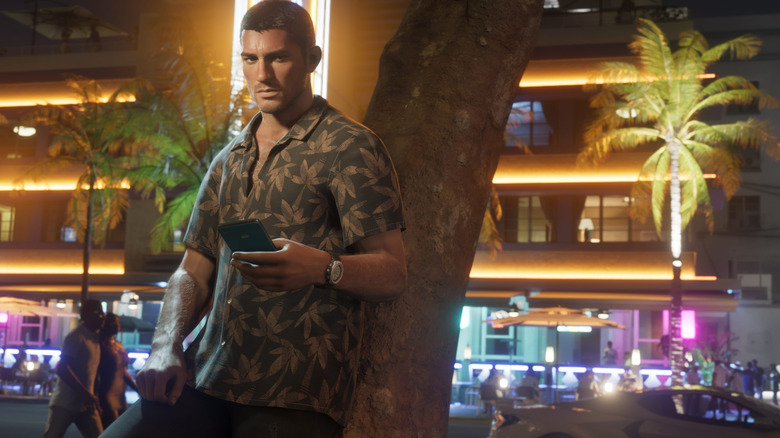 Jason egy fának dőlve mobiltelefonjával a kezében a Grand Theft Auto 6-ban