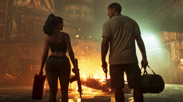 Jason és Lucia táskákkal a kezükben égő autót néznek a Grand Theft Auto VI-ban
