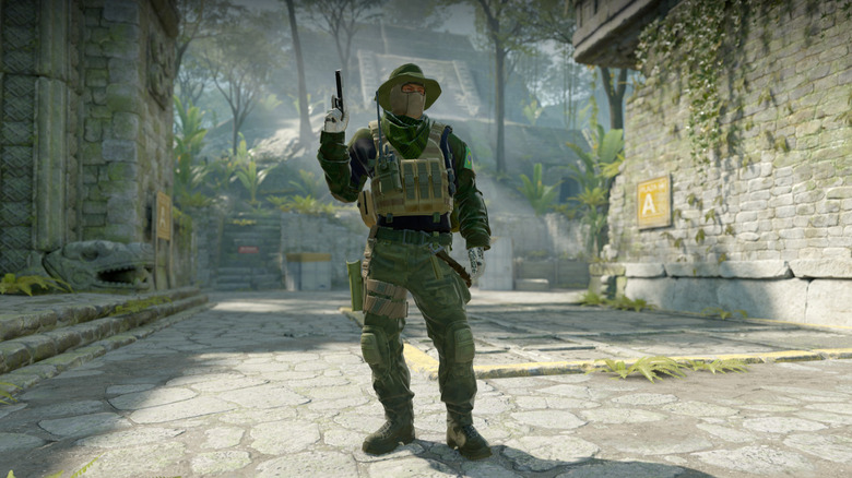 Egy férfi pisztolyt tart egy benőtt utcában a Counter-Strike 2-ben