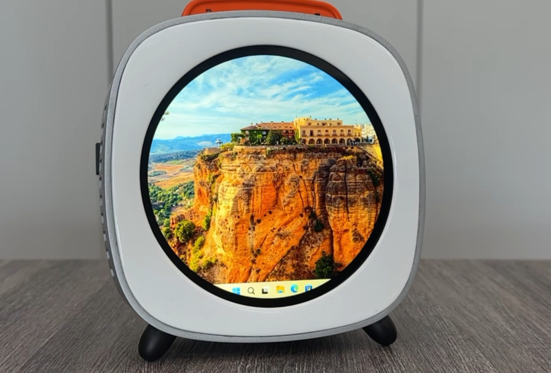 Piston V mini PC with front touchscreen displayed on a desk