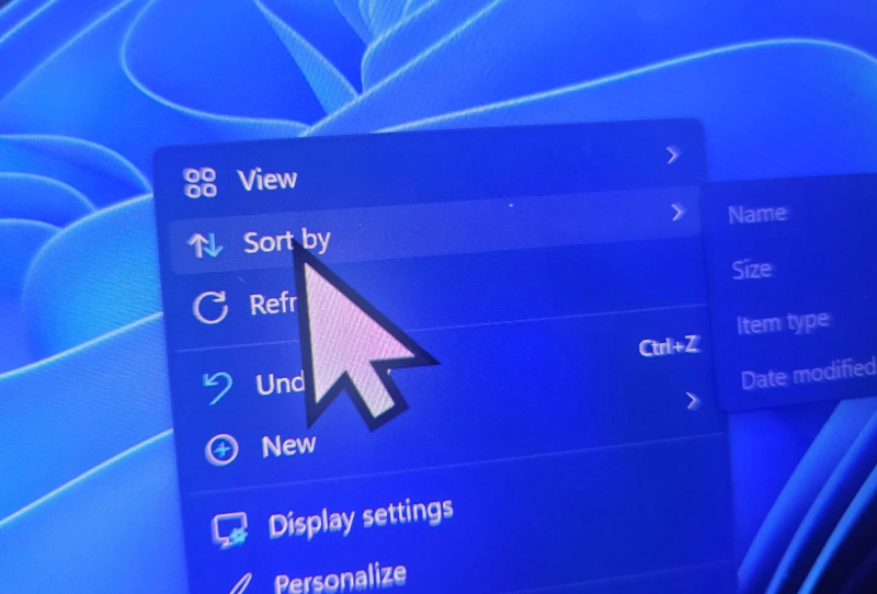 Windows 11 desktop showing a default oversized mouse cursor caused by the KB5120998 cursor bug