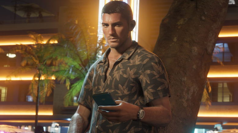 Jason egy fának dőlve tartja a telefont a Grand Theft Auto 6-ban