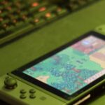 Nintendo Switch console beside a PC representing the Suyu Switch emulator shutting down