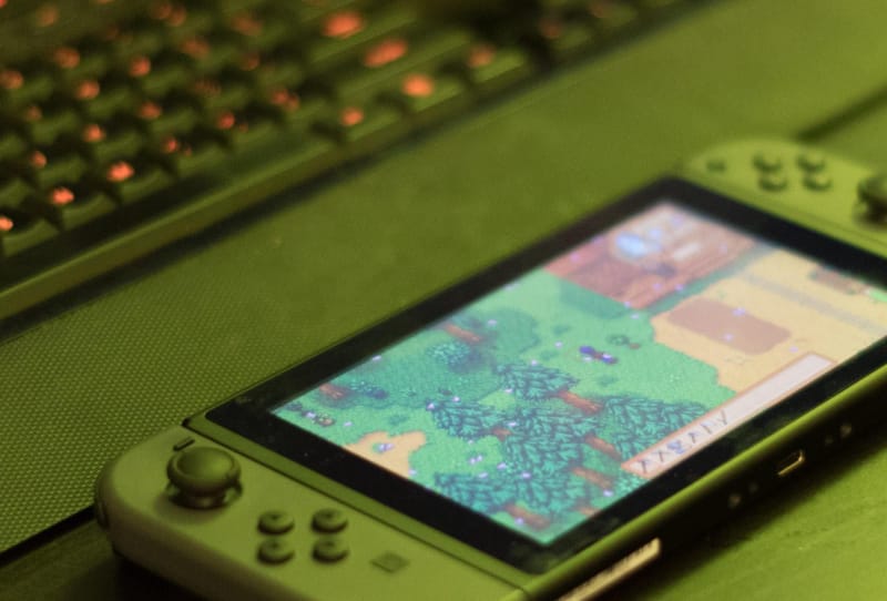 Nintendo Switch console beside a PC representing the Suyu Switch emulator shutting down
