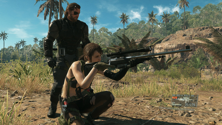 Venom Snake Quiet mögött áll, miközben célba veszi a Metal Gear Solid V: The Phantom Pain játékot.