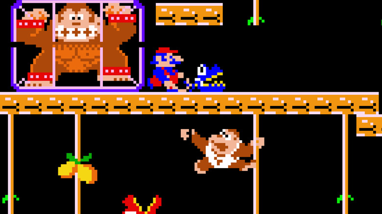 Donkey Kong Jr. felmászik a szőlőre Mario és egy ketrecbe zárt Donkey Kong alatt Donkey Kong Jr.-ban.