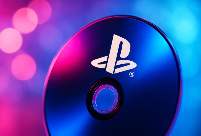 PlayStation controller resting beside PS5 game cases representing PlayStation physical game discs