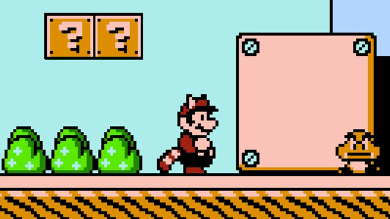Mario a Tanooki-öltönyben egy érkező Goombát néz a Super Mario Bros. 3-ban