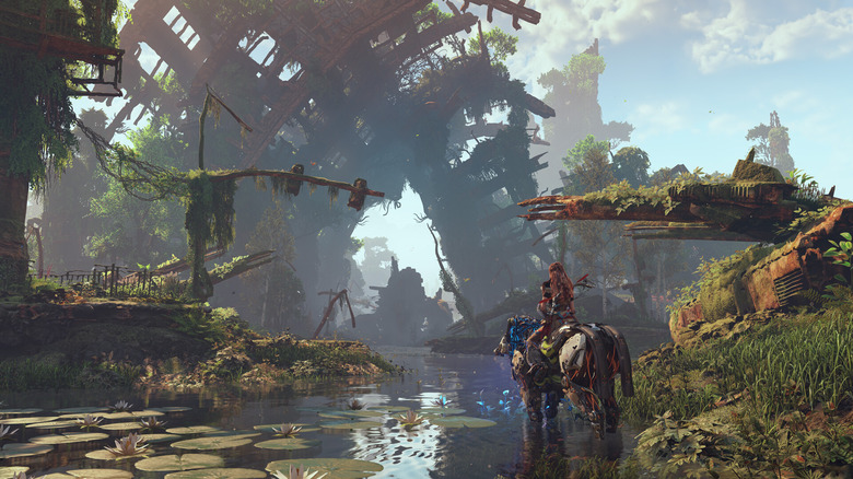 Aloy a Horizon Zero Dawnban mechanikus lovon ülve néz egy romos épületet