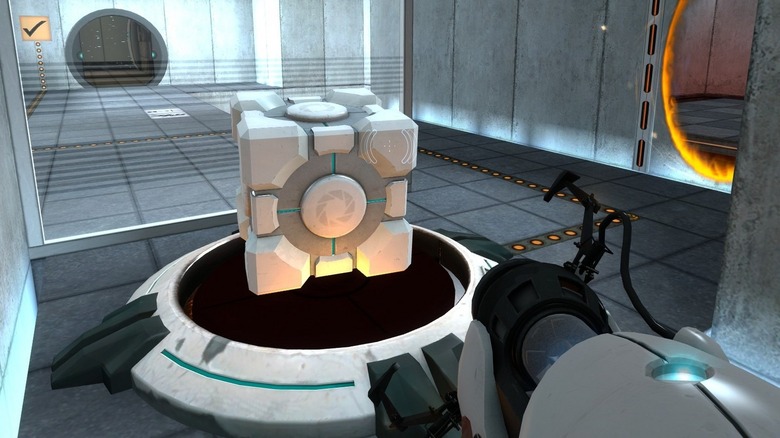 Chell portálfegyverrel közelít egy kockához a Portalban (2007)