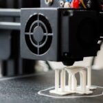 A 3D printer running on a desk in a home office, illustrating 3D printer bedroom safety concerns around ventilation