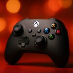 Xbox Nano controller held in one hand next to a smartphone to show its pocket-size footprint