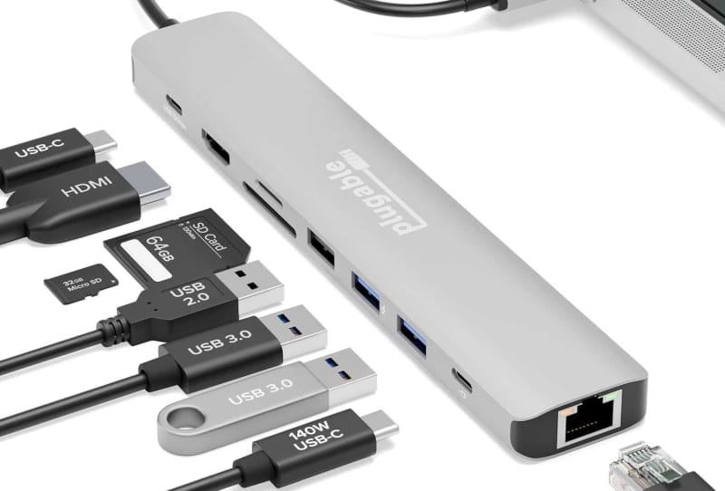 A MacBook Pro connected to a USB-C hub with multiple cables and peripherals attached